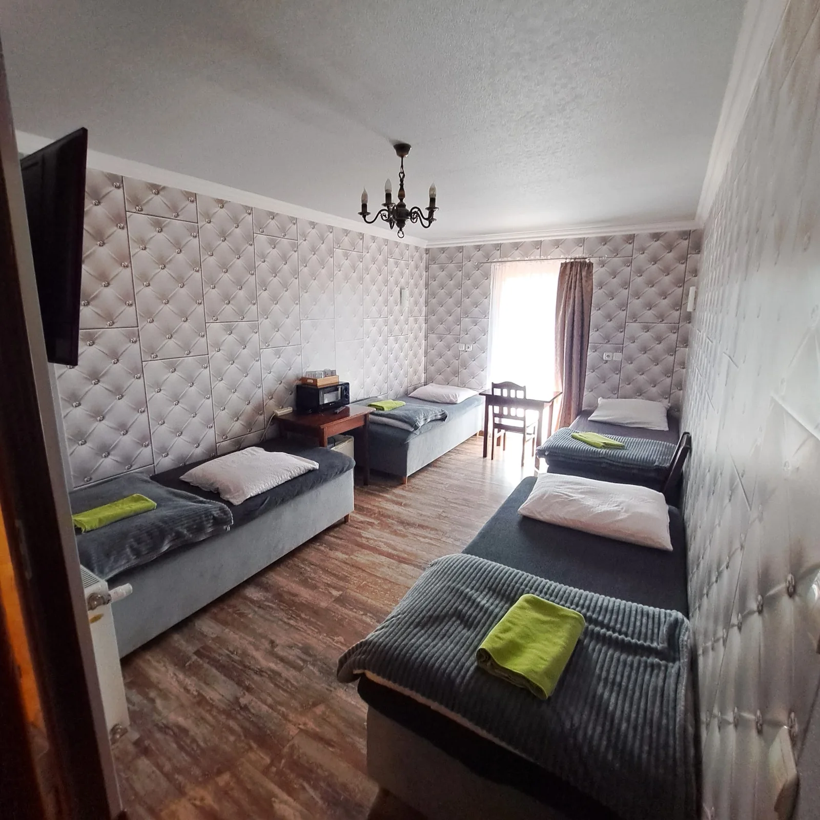 Widok przestronnego pokoju z kilkoma łóżkami